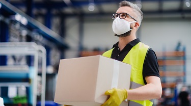 Male warehouse worker carries goods for shipping