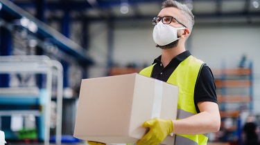 Male warehouse worker carries goods for shipping