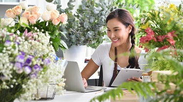 Flower shop owner ordering supplies on her laptop