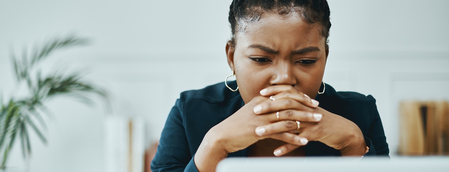 Woman looks confused as she reads a document on her office computer.