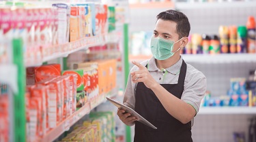 Un commis d’épicerie asiatique fait l’inventaire des stocks.