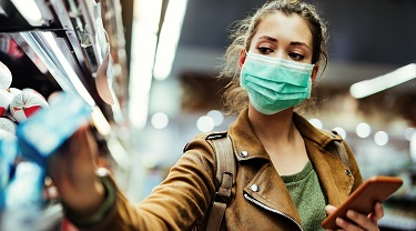 Femme portant un masque de protection à l’épicerie