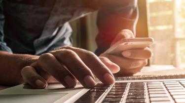 Help with trade to the U.S. is available at your fingertips, demonstrated by this hand on smartphone.