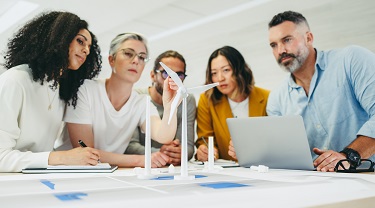 Cinq employés du secteur des technologies propres étudient la conception d'éoliennes solaires