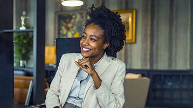 Beautiful black female business owner smiles in boardroom