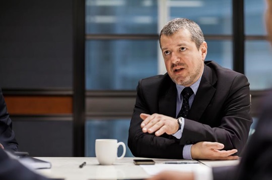 Dans la salle d’un conseil d’administration, un homme présente ses idées.