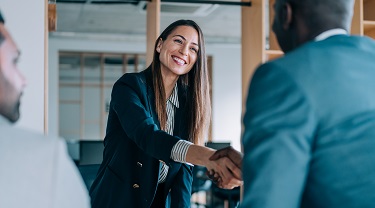 Une experte en commerce accueille des entrepreneurs dans son bureau.