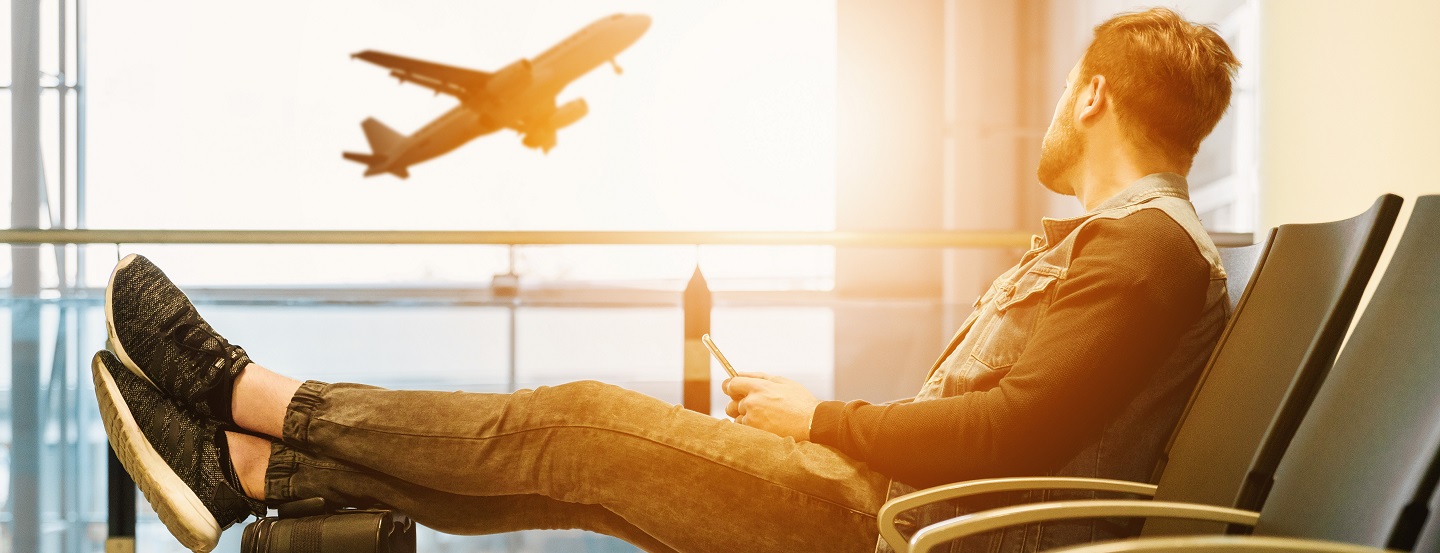 Un homme dans un aéroport qui regarde un avion décoller