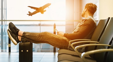 Un homme dans un aéroport qui regarde un avion décoller