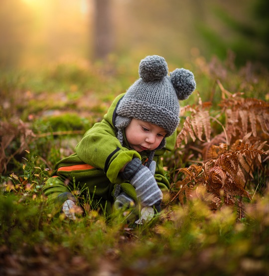 Un enfant porte le produit fini : une tuque avec deux pompons.