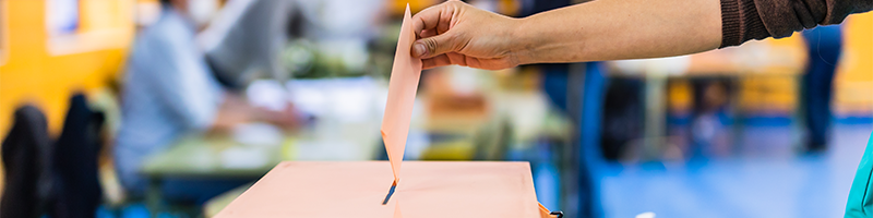 A hand posting a voting ballot during an election