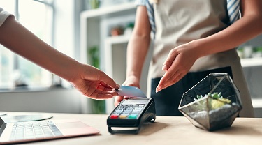 Customer tapping credit card to pay for flowers.