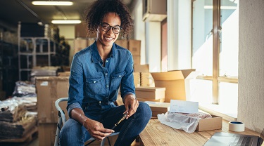 Une femme qui sourit en tenant un style dans un entrepôt