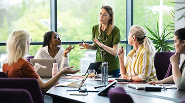 Image of diverse group talking representing EDC’s engagement with multiple groups to identify ESG topics material to EDC