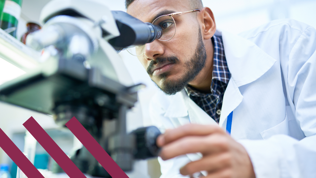 Homme barbu utilisant un microscope