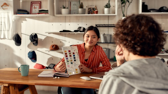 Entrepreneur shows sample colour swatches to prospective customer.