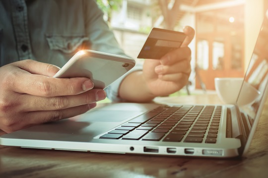 Un homme paie sa commande en ligne avec une carte de crédit.