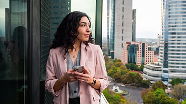 Une exportatrice canadienne cherchant des stratégies de tarification internationale sur son téléphone à Mexico.