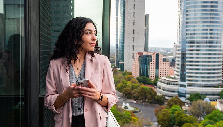 Canadian exporter researching international pricing strategies on her phone in Mexico City.
