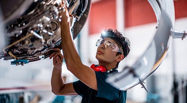 Aircraft mechanic checks engine.