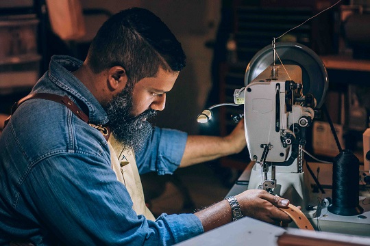 Homme qui travaille à une machine à coudre ou à broder