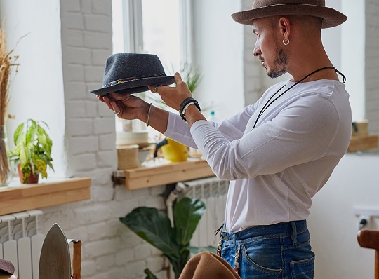 Un tailleur vérifie son chapeau fait à la main avant de le vendre