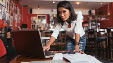 L'entrepreneur féminin regarde impatiemment l'ordinateur