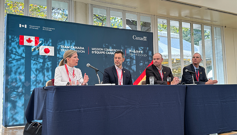 A four member seated panel from a Canadian trade mission speaks to an audience of exporters at a trade event in Japan