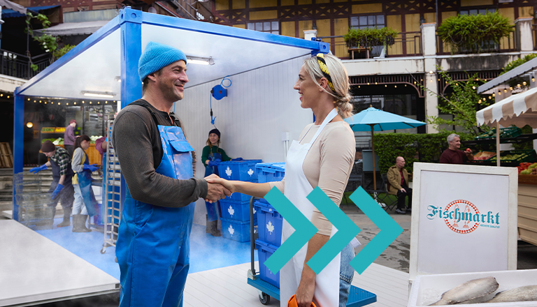 Deux personnes se serrent la main dans un marché aux poissons, représentant des exportateurs canadiens élargissant le commerce au-delà des États-Unis.