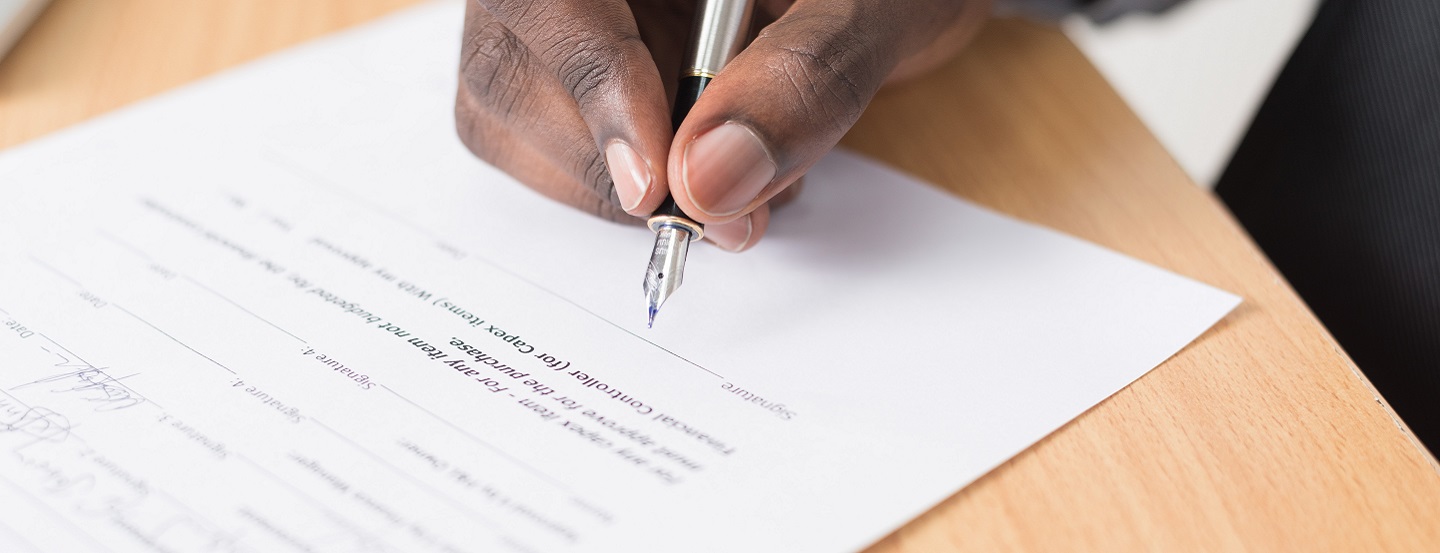 A man signs a contract.