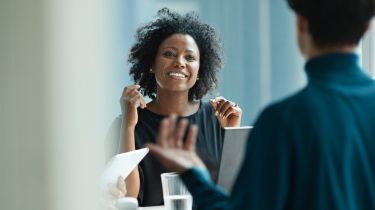 Une femme noire participant à une réunion avec des collègues