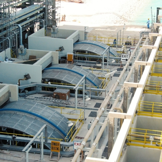 Industrial water treatment equipment with circular screening systems and access walkways.