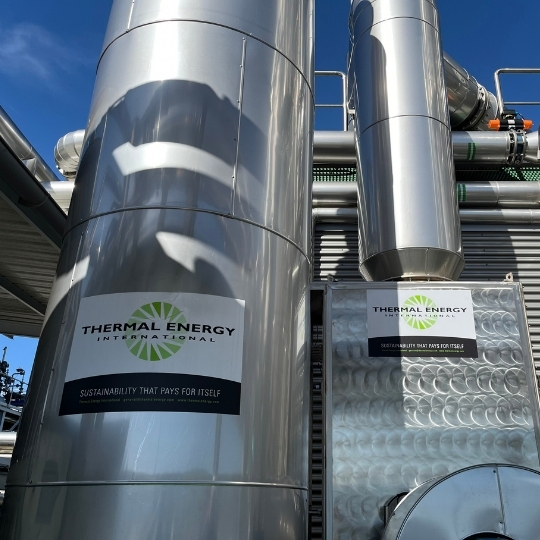 Large metal tanks and piping in an industrial energy facility.