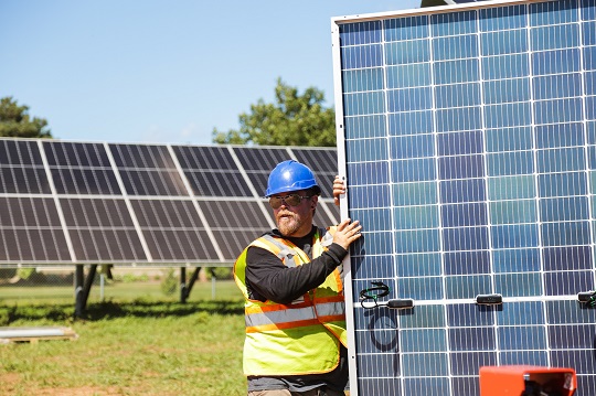 Membre de l’équipe AKA installant des panneaux solaires