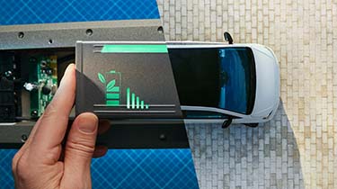 Image divisée d’une personne tenant une batterie (à gauche) et d’une vue aérienne d’une voiture électrique (à droite).