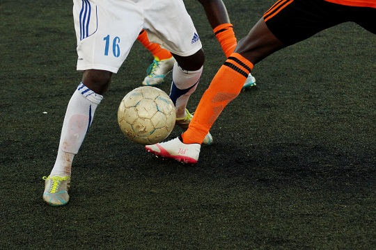 Two soccer players compete for the ball.