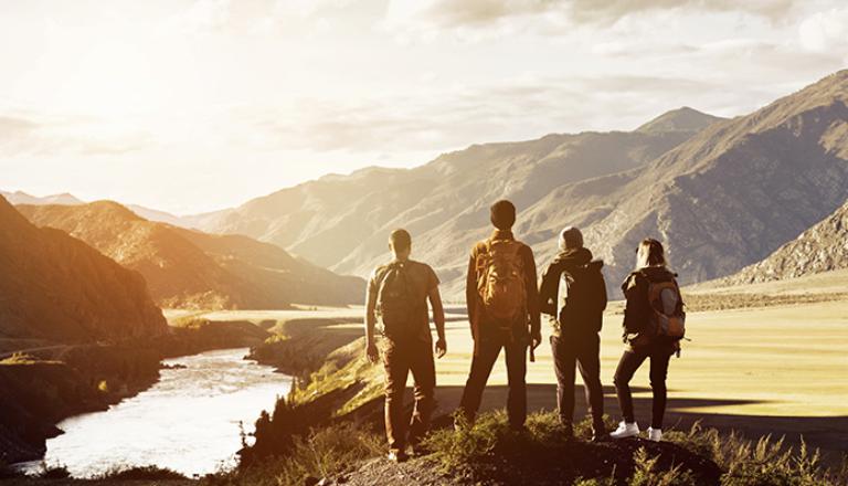 A team of hikers surveys a mountainous landscape to strategize their way forward.