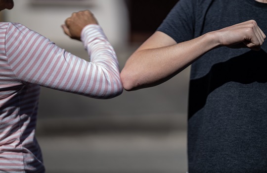 Two people touching elbows