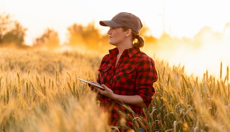 Agricultrice avec tablette dans un champ de blé