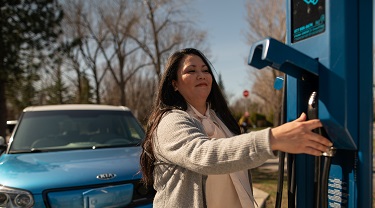 Woman plugging in her electric vehicle. 