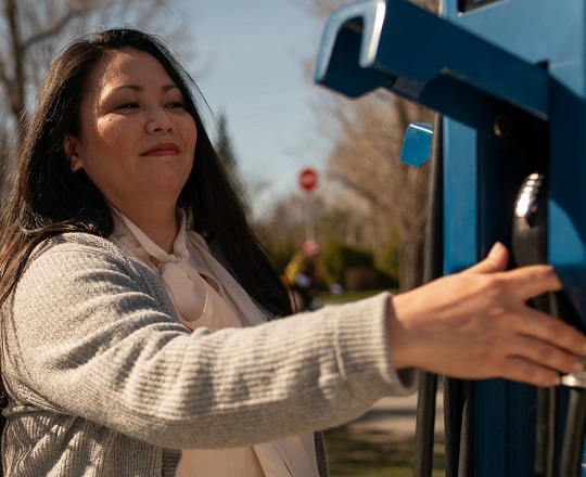 Woman plugging in her electric vehicle. 