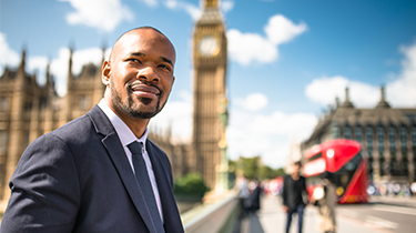 Black businessman walks in front of London’s Big Ben