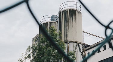 Fermée en raison de la COVID-19, une usine déserte se dresse derrière une clôture de métal.