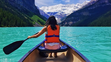 Une femme qui pagaye en canot sur le lac Moraine