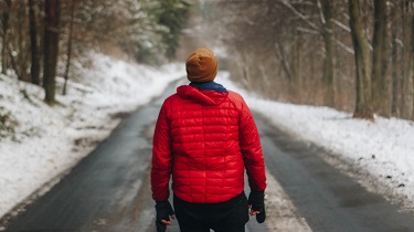 Man walks down middle of road, facing the future