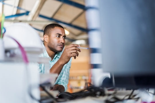 Black professional concentrating while looking at computer screen