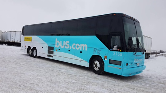 Chartered bus with Bus.com’s logo on it.