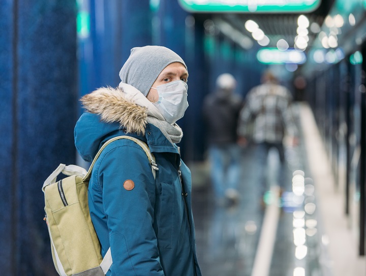 Un homme portant le masque attend son train