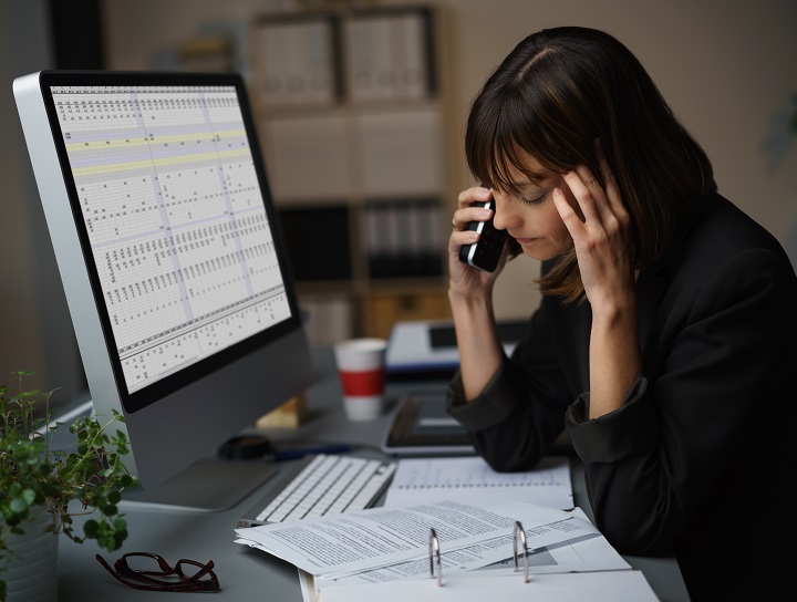 Femmes d’affaires affichant un air préoccupé alors qu’elle travaille à son ordinateur.