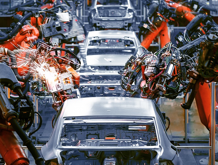 Des machines construisent des véhicules dans une usine.